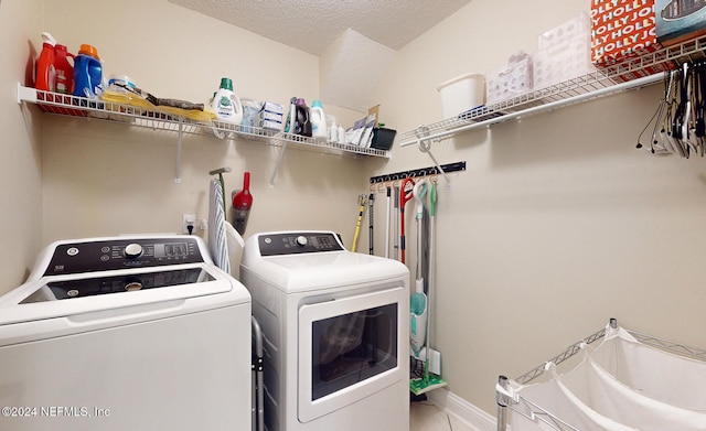 laundry room featuring a textured ceiling and washer and clothes dryer