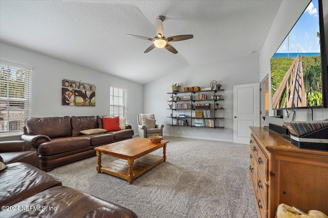 carpeted living room with a textured ceiling, ceiling fan, a healthy amount of sunlight, and vaulted ceiling