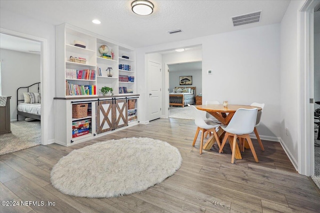 interior space with a textured ceiling and hardwood / wood-style flooring