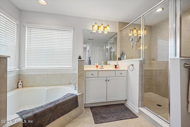 bathroom featuring plus walk in shower, a textured ceiling, vanity, and tile patterned floors