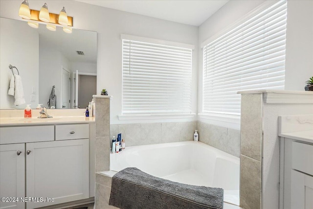 bathroom with vanity and a tub