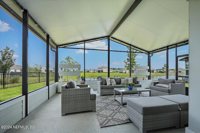 sunroom featuring vaulted ceiling and a water view