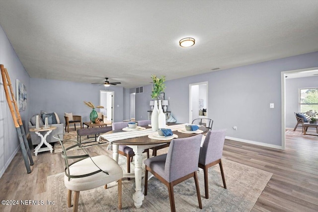 dining room with a textured ceiling, hardwood / wood-style flooring, and ceiling fan