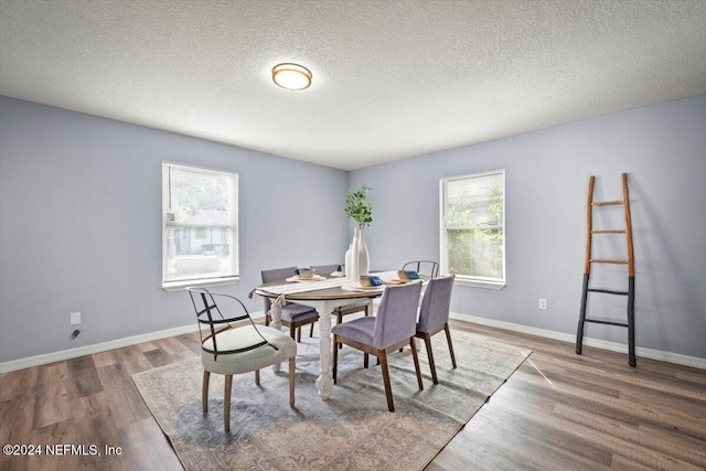 dining area with hardwood / wood-style flooring and a textured ceiling