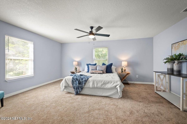 carpeted bedroom with a textured ceiling and ceiling fan