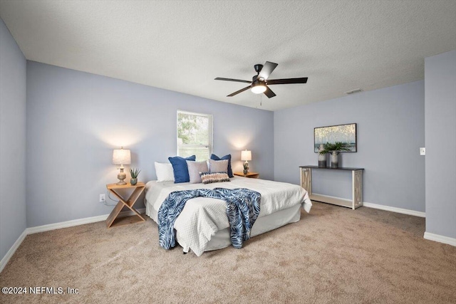 bedroom featuring carpet flooring, ceiling fan, and a textured ceiling