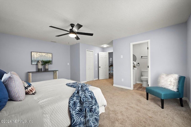 carpeted bedroom with ensuite bath, ceiling fan, and a textured ceiling