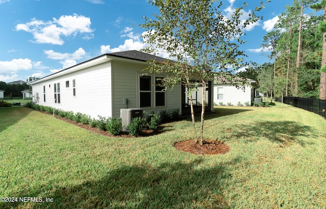 view of property exterior with central air condition unit and a yard