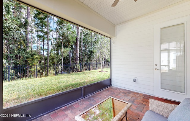 unfurnished sunroom with ceiling fan and plenty of natural light