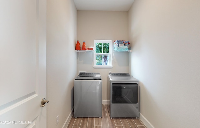 laundry area with washing machine and clothes dryer and hardwood / wood-style floors