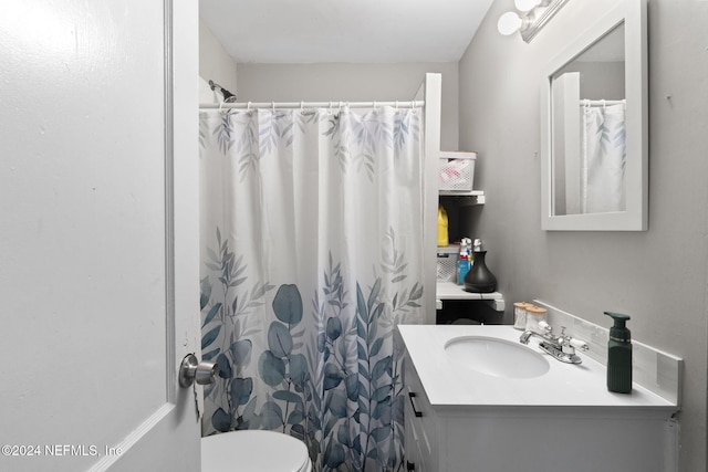 bathroom with curtained shower, vanity, and toilet