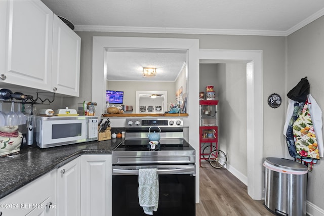 kitchen featuring white cabinetry, light wood-type flooring, stainless steel range with electric stovetop, and ornamental molding