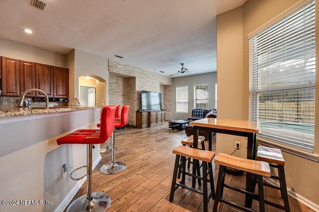 interior space featuring ceiling fan, sink, a textured ceiling, and light hardwood / wood-style flooring