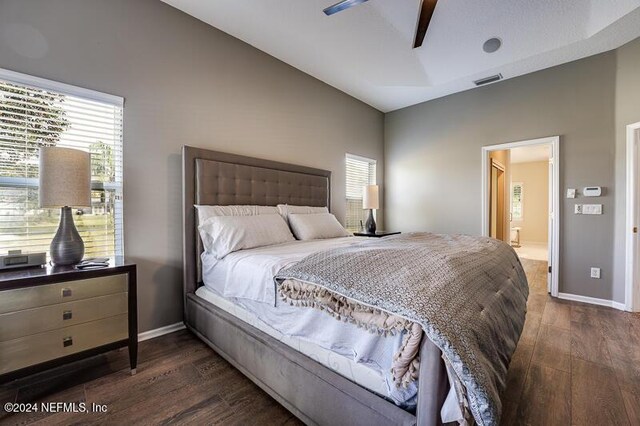 bedroom featuring multiple windows, dark hardwood / wood-style floors, and ceiling fan