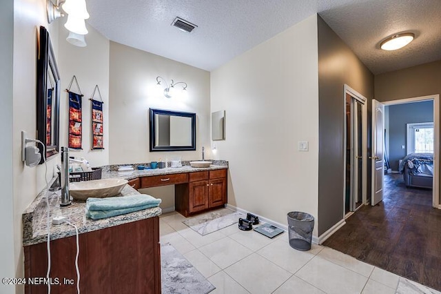 bathroom with vanity, tile patterned floors, and a textured ceiling