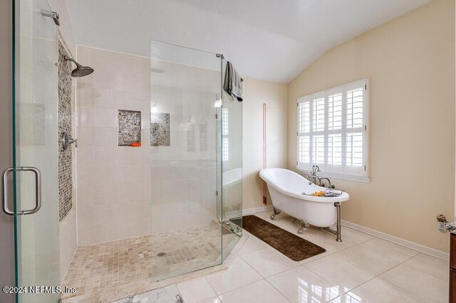 bathroom with plus walk in shower, lofted ceiling, and tile patterned floors