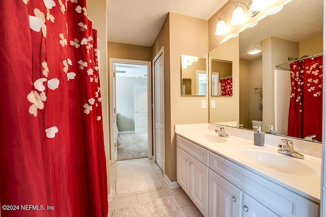 bathroom with toilet, a textured ceiling, vanity, a shower with shower curtain, and tile patterned flooring