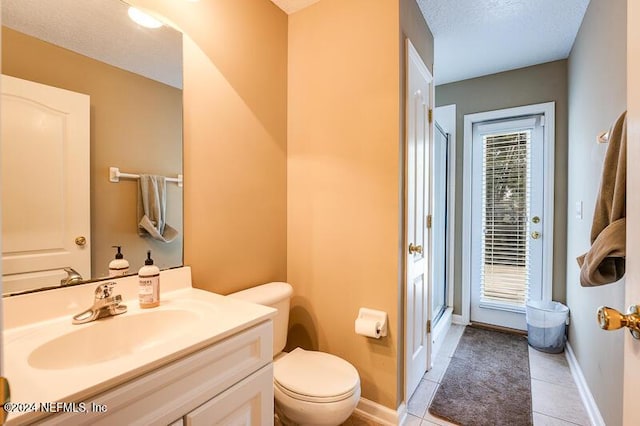 bathroom featuring vanity, a textured ceiling, toilet, and walk in shower