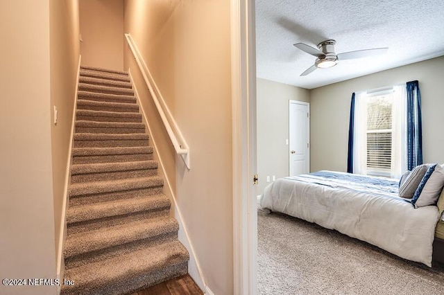 bedroom with ceiling fan and a textured ceiling