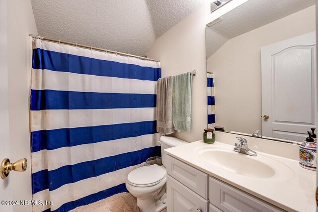 bathroom with walk in shower, vanity, toilet, and a textured ceiling