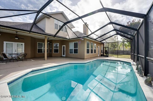 view of swimming pool with french doors, ceiling fan, a lanai, and a patio area