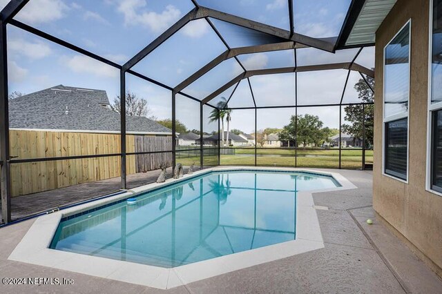 view of swimming pool featuring a lanai and a patio