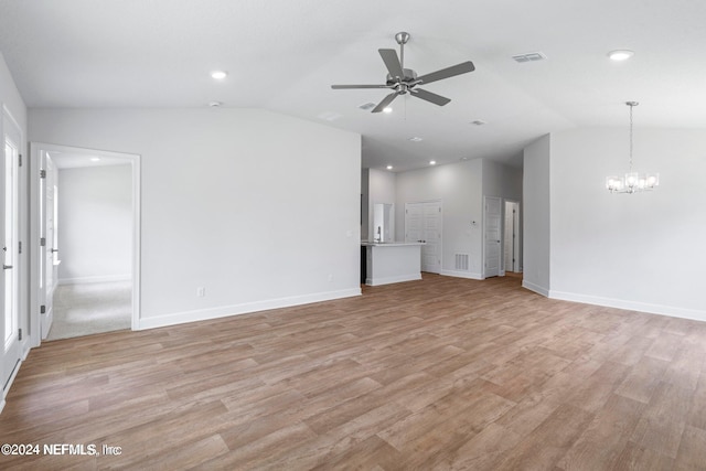 unfurnished living room featuring light hardwood / wood-style floors, ceiling fan with notable chandelier, and vaulted ceiling