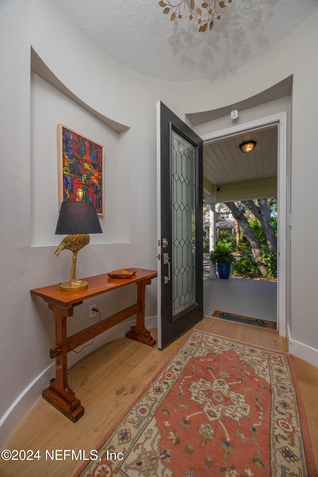 foyer featuring light wood-type flooring and a textured ceiling