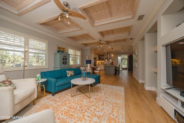 living room with crown molding, light wood-type flooring, beam ceiling, coffered ceiling, and ceiling fan