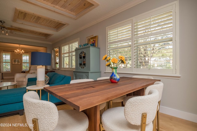 dining space featuring light hardwood / wood-style floors, a notable chandelier, and ornamental molding