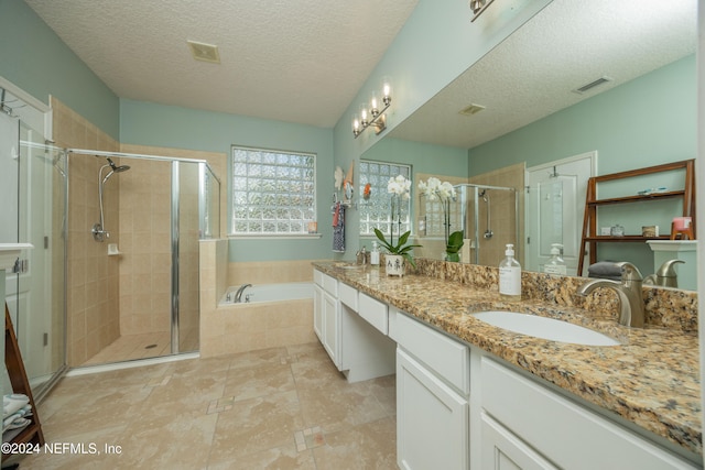 bathroom with vanity, independent shower and bath, and a textured ceiling