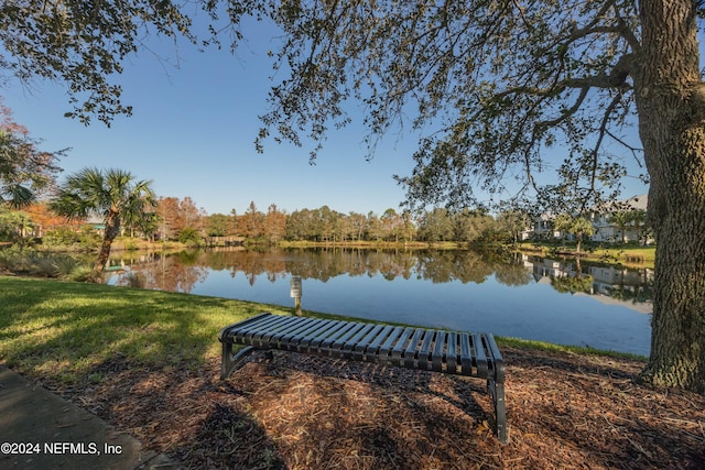 view of dock with a water view and a yard