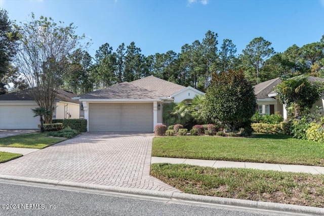 ranch-style house with a garage and a front yard