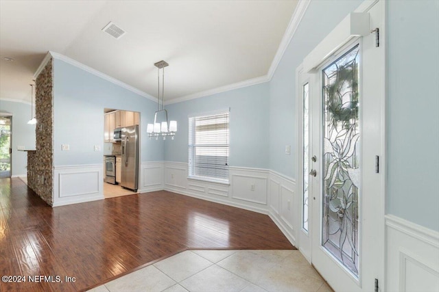 unfurnished dining area with ornamental molding, light hardwood / wood-style floors, a chandelier, and vaulted ceiling