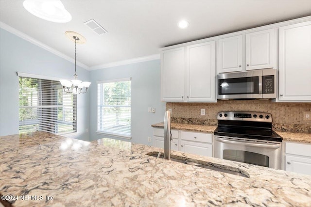 kitchen with pendant lighting, decorative backsplash, crown molding, white cabinetry, and appliances with stainless steel finishes