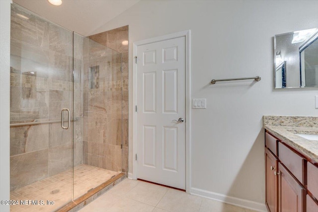 bathroom with tile patterned flooring, vanity, vaulted ceiling, and a shower with door