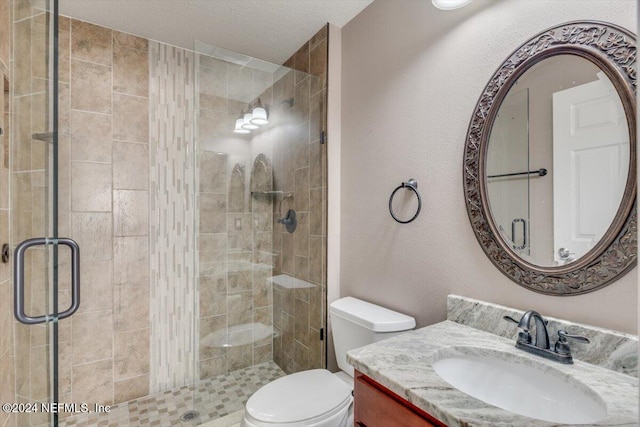 bathroom featuring vanity, toilet, and an enclosed shower