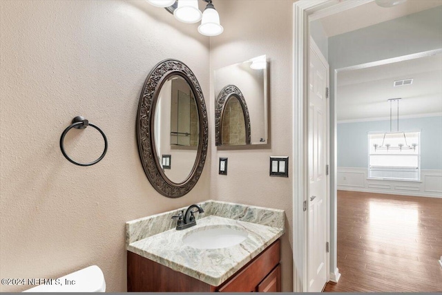 bathroom featuring hardwood / wood-style floors, vanity, and crown molding