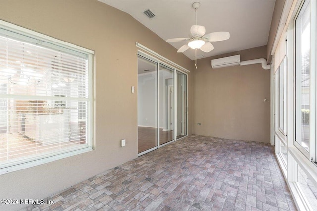 unfurnished sunroom with ceiling fan, an AC wall unit, and lofted ceiling