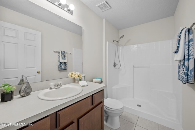 bathroom with tile patterned flooring, a textured ceiling, vanity, a shower, and toilet