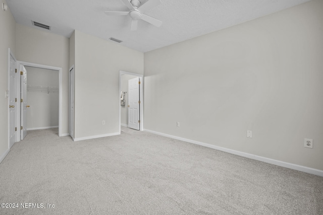 unfurnished bedroom with ceiling fan, light carpet, and a closet