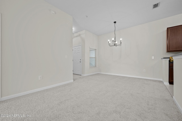 unfurnished room with light colored carpet and a chandelier