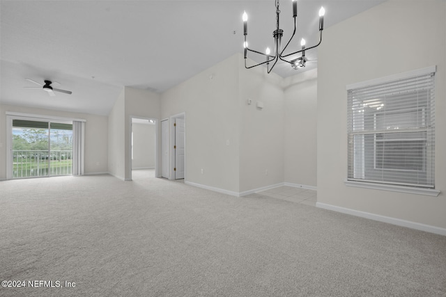 carpeted empty room with ceiling fan with notable chandelier