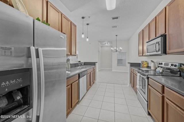 kitchen featuring stainless steel appliances, light tile patterned floors, hanging light fixtures, sink, and a chandelier