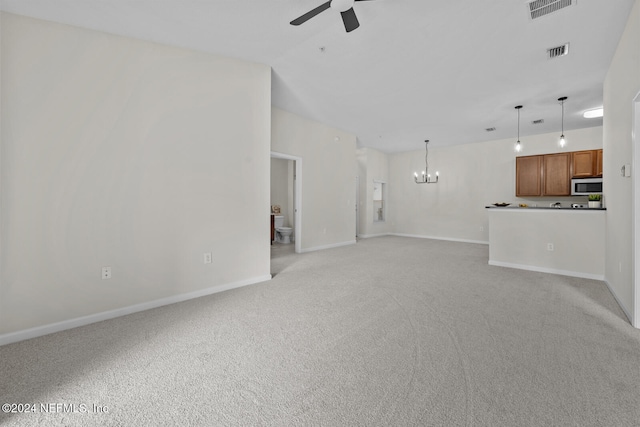 unfurnished living room featuring light colored carpet and ceiling fan with notable chandelier