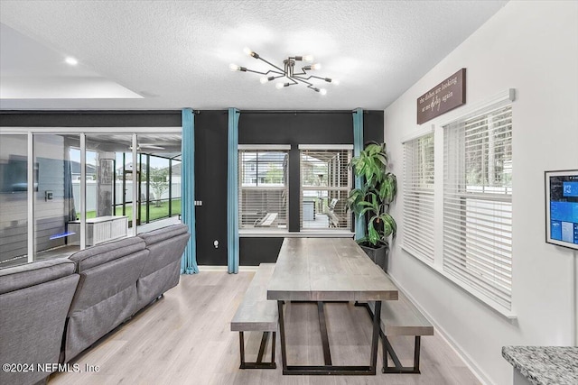 interior space with a textured ceiling, light hardwood / wood-style flooring, and a notable chandelier