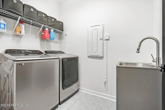 laundry room featuring washing machine and dryer, electric panel, sink, and light tile patterned floors