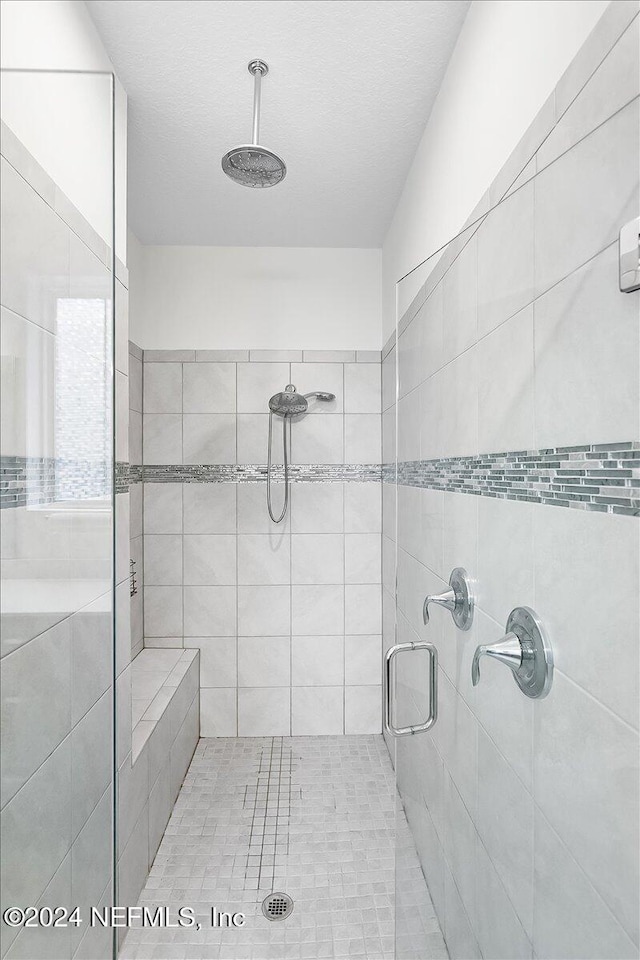 bathroom featuring walk in shower and a textured ceiling