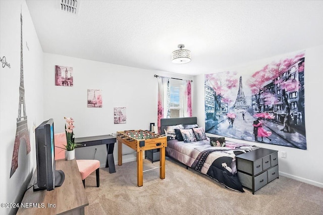 bedroom with light colored carpet and a textured ceiling