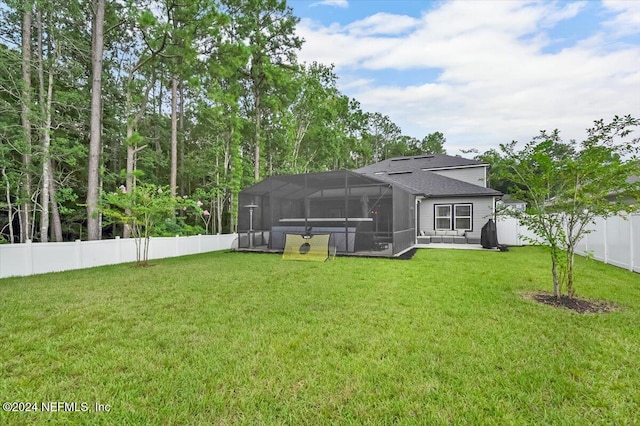 rear view of property with glass enclosure and a yard